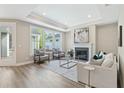 Bright and airy living room with a fireplace, tray ceiling, and large windows at 248 Persimmon Dr, Holly Springs, GA 30115