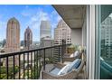 Relaxing condo balcony with comfortable chairs and a panoramic view of the city skyline at 1080 Peachtree Ne St # 2512, Atlanta, GA 30309