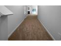 Inviting hallway featuring neutral paint and carpet leading to a cozy living space with sliding glass doors at 4106 Dahlgreen Way, Decatur, GA 30032