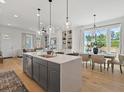 Open concept kitchen with an island and stainless steel appliances overlooking dining and living areas at 689 Dobbs Rd, Woodstock, GA 30188