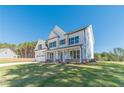 Two-story white farmhouse with brick accents, large windows, and a spacious yard at 91 Pinewood Dr, Covington, GA 30014