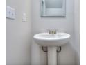 Close-up of a pedestal sink in a bathroom featuring a framed mirror and classic fixtures for a clean, minimalist aesthetic at 3405 Ripple Loop # 127, South Fulton, GA 30349