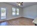 Open bedroom featuring wood-look floors, a ceiling fan, with natural light streaming in from large windows and the glass pane door at 3405 Ripple Loop # 127, South Fulton, GA 30349