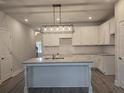 Modern kitchen featuring white cabinets, subway tile backsplash, granite countertops and island with sink at 3405 Ripple Loop # 127, South Fulton, GA 30349