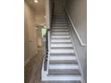 A staircase features wood-look flooring, white risers, and a dark wood handrail at 3405 Ripple Loop # 127, South Fulton, GA 30349