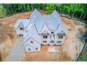 An aerial view shows a new two-story home with gray roof on a large lot in a wooded area at 2675 Drayton Hall Dr, Buford, GA 30519