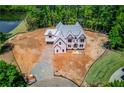 A partially completed two-story home is on a large lot, surrounded by mature trees and landscaping at 2675 Drayton Hall Dr, Buford, GA 30519