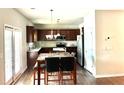 Eat-in kitchen featuring dark wood cabinetry, modern appliances, tiled backsplash, and a sunny breakfast area at 389 Meeting St, Mcdonough, GA 30252