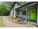 Inviting front porch featuring a vibrant green door and thoughtfully landscaped garden at 626 Dover St, Marietta, GA 30066