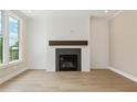 Modern fireplace with white shiplap wall and beautiful hardwood floors in the living room at 5210 Ginger Rose Ct, Cumming, GA 30028
