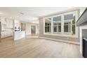 Open concept living area with hardwood floors and bright light flowing in from large windows at 5210 Ginger Rose Ct, Cumming, GA 30028