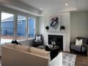 Cozy living room featuring a fireplace, large windows, and ample seating at 309 Sassafras Way, Holly Springs, GA 30115