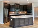 Modern kitchen features dark cabinets, stainless steel appliances, and a large island at 313 Sassafras Way, Holly Springs, GA 30115