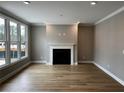 Bright living room featuring hardwood floors, a fireplace, and large windows at 313 Sassafras Way, Holly Springs, GA 30115
