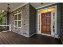 Inviting front porch with stone accents and hardwood flooring at 7655 Abbey Glen Dr, Cumming, GA 30028