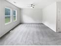 Spacious bedroom with plush carpet, neutral colors, and natural light from large windows at 55 Cherohala Ct, Covington, GA 30016