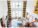 Bright and open living room with soaring ceilings, fireplace, and large windows with decorative drapes at 4850 Guilford Forest Sw Dr, Atlanta, GA 30331