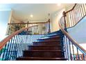 Elegant curved staircase with wrought iron railing adds architectural detail to the home's entryway at 4850 Guilford Forest Sw Dr, Atlanta, GA 30331