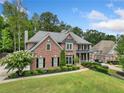 Beautiful two-story brick home with manicured lawn and lush landscaping creating a picturesque and welcoming ambiance at 719 Settlers Xing, Canton, GA 30114