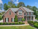 Charming two-story brick home with landscaped yard and covered porch, offering classic curb appeal and an inviting entrance at 719 Settlers Xing, Canton, GA 30114
