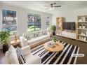 Bright living room featuring a modern striped rug, white sofa, and ample natural light from large windows at 1575 Ridenour Nw Pkwy # 804, Kennesaw, GA 30152
