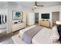 Light-filled main bedroom with minimalist decor, plush rug, and large dresser under wall-mounted TV at 1575 Ridenour Nw Pkwy # 804, Kennesaw, GA 30152