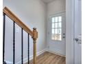 Bright entryway with wood-look floors, stylish staircase, and glass-paned front door at 6198 Ripple Way # 87, South Fulton, GA 30349