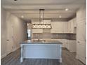 Open concept kitchen featuring granite counters, an island with a sink, and white cabinets at 6202 Ripple Way # 88, South Fulton, GA 30349