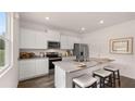 New kitchen features stainless appliances, granite countertops, gray cabinets and hardwood floors at 126 Oakchase Park Ln, Hampton, GA 30228