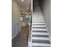 View of staircase and open floor plan with gray wood flooring and access to the kitchen at 6214 Ripple Way # 91, South Fulton, GA 30349