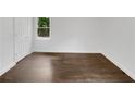 A bright empty bedroom features light walls and new dark wood flooring at 1909 Meadow Ln, Decatur, GA 30032