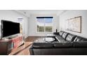 Comfortable living room with dark wood floors, black leather couch and expansive windows at 3445 Stratford Ne Rd # 3601, Atlanta, GA 30326