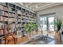 Charming living room featuring a bookshelf, wood floors, a decorative rug, and access to the balcony at 805 Peachtree Ne St # 401, Atlanta, GA 30308