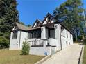 Charming white brick home with dark brown accents and a landscaped lawn at 1677 S Gordon Sw St, Atlanta, GA 30310