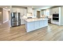 Bright, open kitchen with a center island, stainless steel appliances, and light wood flooring at 738 Crossroad Ct, Powder Springs, GA 30127