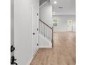 Inviting entryway featuring wood floors, a staircase with white railings, and a visible doorway ahead at 404 Beacon Way, Villa Rica, GA 30180