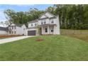 Well-maintained two-story house with a lush green lawn on a sloped lot, surrounded by trees at 404 Beacon Way, Villa Rica, GA 30180