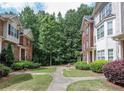 Well-manicured courtyard showing a charming community with brick townhomes and a lush garden at 2382 Gallard St, Lawrenceville, GA 30043