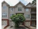 Exterior shot of a townhome highlighting gray siding, brick accents, and attached garages at 2382 Gallard St, Lawrenceville, GA 30043