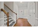 Bright foyer features hardwood floors, white wainscoting, and staircase leading to the upper level at 6329 Edgewater Cv, Fairburn, GA 30213