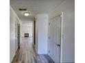 Bright hallway with fresh paint, white trim, wood-look flooring, and a view to the living area at 6693 Villa Ct # 6693, Lithonia, GA 30038