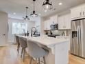 Modern kitchen with stainless steel appliances, a large kitchen island, and stylish pendant lighting at 1899 Deco Dr, Kennesaw, GA 30144