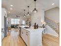 Open concept kitchen with stainless appliances, waterfall island, and seamless flow to the living area and stairway at 1899 Deco Dr, Kennesaw, GA 30144