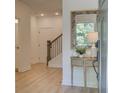 Inviting entryway featuring wood floors, stairs, and a stylish console table with a decorative mirror at 1995 Deco Dr, Kennesaw, GA 30144