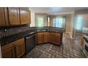Functional kitchen featuring stone countertops, stainless steel appliances, and natural wood cabinets with tile backsplash at 7030 Valley Landing Ct, Cumming, GA 30041