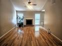 Inviting living room featuring gleaming hardwood floors, a classic fireplace, and bright windows with natural light at 7030 Valley Landing Ct, Cumming, GA 30041