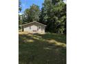 Back view of the house showing a spacious backyard and trees at 130 Taunton Rd, Covington, GA 30014