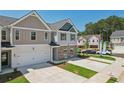 Two-story townhome with gray and beige exterior, white garage door, and landscaping; aerial view at 158 Switcher Ct, Union City, GA 30291