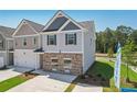 Two-story townhome with gray and beige siding, two-car garage, and landscaping at 150 Switcher Ct, Union City, GA 30291