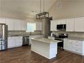 Modern kitchen featuring white cabinets, granite countertops, stainless steel appliances, and a center island at 1250 Adamson Rd, Bowdon, GA 30108